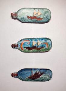 Three sailing waka in a bottle